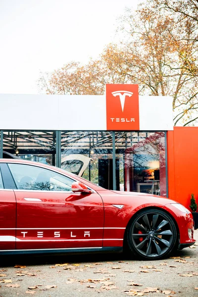 Nowy salon Tesla Model S zaparkowany przed czerwony salon wystawowy — Zdjęcie stockowe