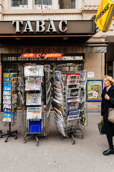 Женщина, идущая перед французским киоском для прессы Стивен Хокинг Ди
