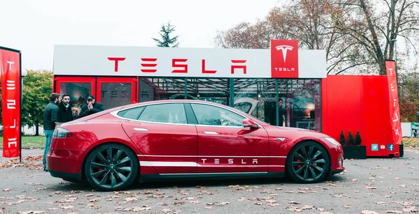 Nowy salon Tesla Model S zaparkowany przed czerwony salon wystawowy — Zdjęcie stockowe