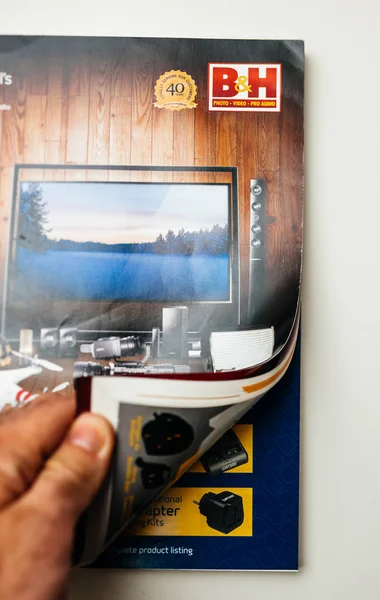 Homem lendo American B e H Catálogo profissional de áudio e vídeo — Fotografia de Stock