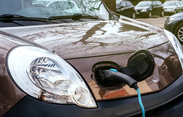 Vista frontal Enchufe en mini-van coche eléctrico en la calle electr —  Fotos de Stock