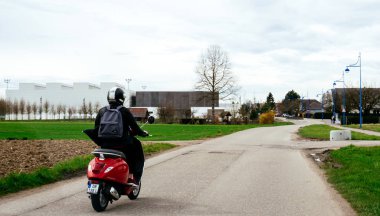 Strasbourg, Fransa - 2 Nisan 2018: İtalyan Vespa Primavera 5 kırmızı Strasbourg yakınındaki bir kırsal yolda sürme kaygısız genç kadın 