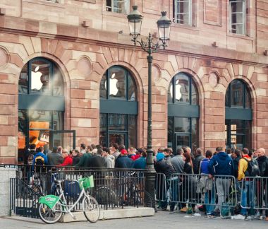 STRASBOURG, FRANCE - SEP, 19 2014: Crowd in line queue in front of Apple Store with customers waiting in line to buy the latest iPhone iPad Apple Watch and notebook clipart