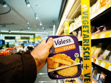 Frankfurt, Almanya - 25 Kasım 2017: Erkek müşteri Alman süpermarkette Edeka - sağlıklı bir yaşam için taze sebzeli biftek seçimi vejetaryen ve vegan gıda satın bakış