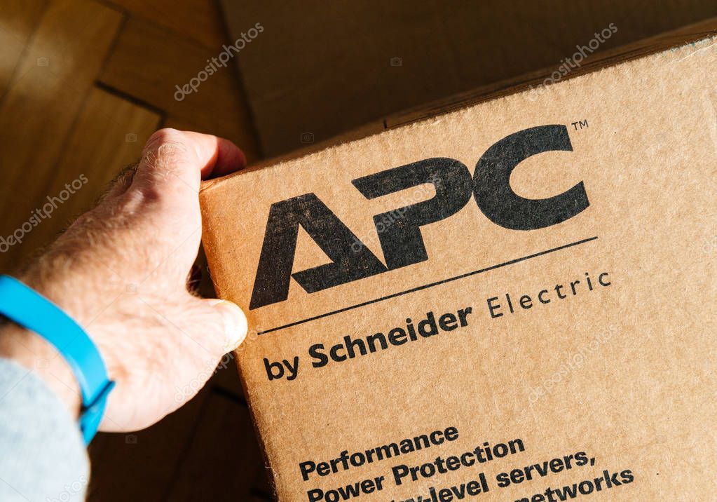 PARIS, FRANCE - MAR 29, 2018: man holding hand near the logo of APC Smart-UPS C enterprise-level uninterruptible power supplies made by American Power Conversion Schneider Electric