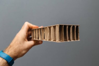 Fabrika işçisi erkek el gri arka planı Oluklu karton karton kağıt ambalaj için arıyorum. 