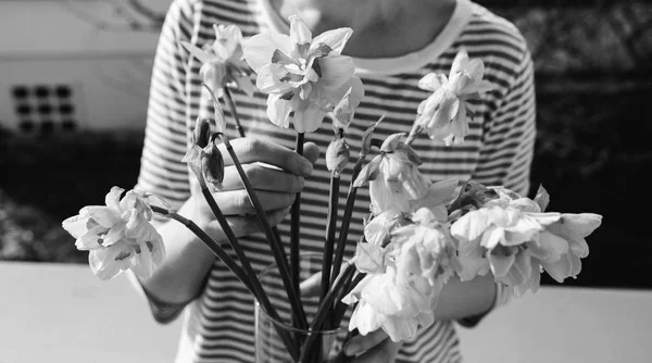 Frau hält Vase mit Narzissen — Stockfoto