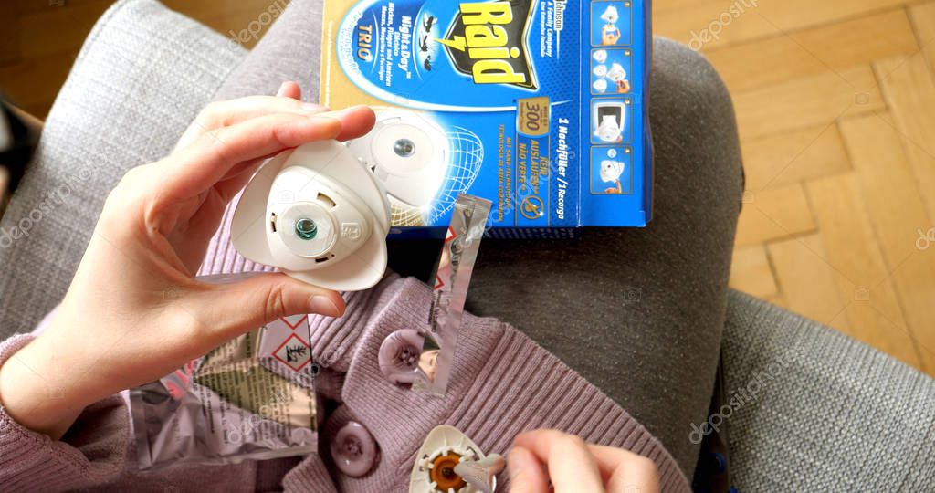 PARIS, FRANCE - SEP 12, 2017: POV woman hands unboxing unpacking new Raid anti mosquito fumigator repellent and Insecticides made by SC Johnson