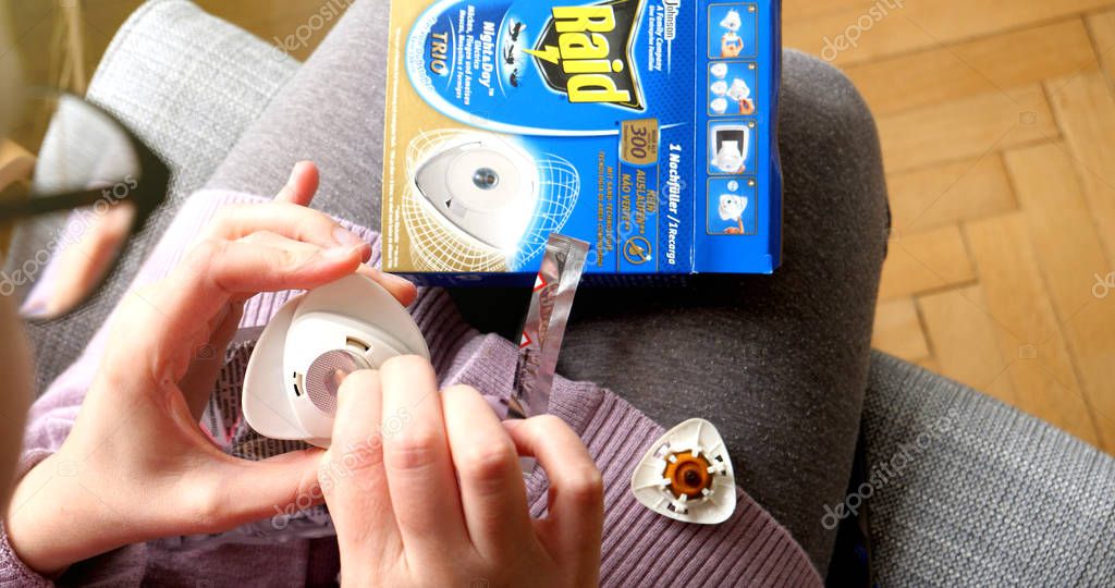 PARIS, FRANCE - SEP 12, 2017: Woman unboxing preparing unpacking new Raid anti mosquito fumigator repellent and Insecticides made by SC Johnson