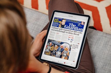 Ipad tabletindeki Apple haber uygulamasında okuyan kadın