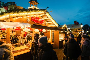 Turistler ve yerliler efsanevi Noel pazarının önünden geçiyorlar.