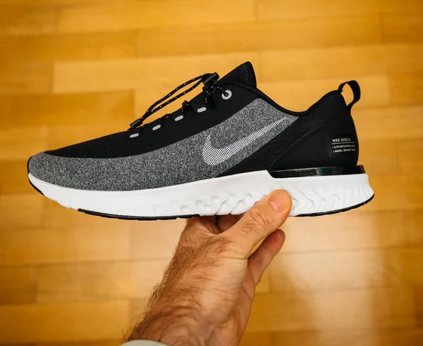 Mano del hombre sosteniendo el nuevo Nike Running Shoe Odyssey React Shield —  Fotos de Stock