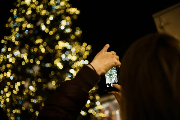 Teléfono inteligente mujer en ascenso para tomar una fotografía mercado de Navidad —  Fotos de Stock