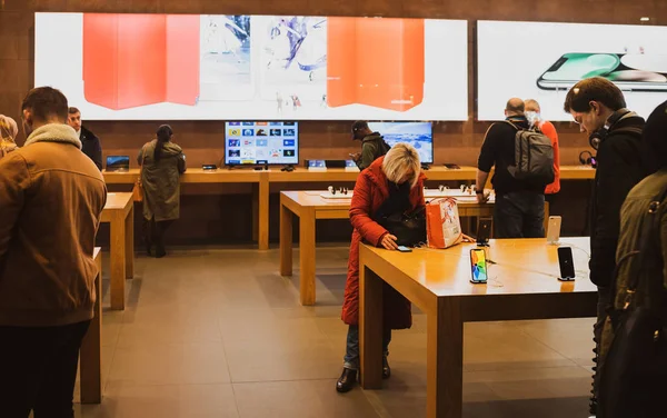 Personas dentro de Apple Store admirando el último teléfono inteligente iPhone —  Fotos de Stock