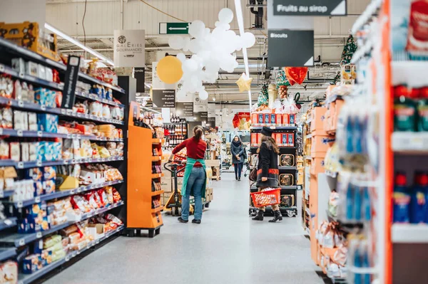 Μεγάλα γαλλικά σούπερ μάρκετ Auchan με εργαζόμενο τακτοποίηση εμπορευμάτων — Φωτογραφία Αρχείου