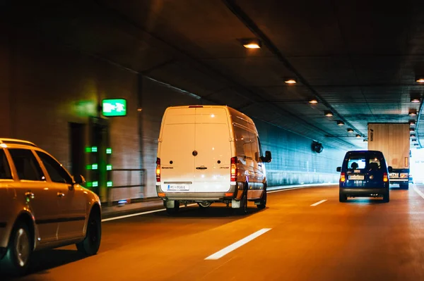 Rear view of multiple cars vans exiting tunnel — Stock Photo, Image