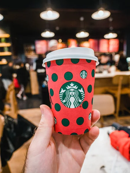 Człowiek ręka trzyma Starbucks czerwony plastik na wynos filiżanka kawy — Zdjęcie stockowe