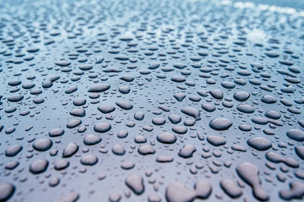 Primer plano de la superficie de pintura limpia del coche con múltiples gotas de agua — Foto de Stock