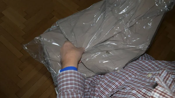 Старший человек распаковывает пластиковые пакеты Uniqlo магазинов — стоковое фото