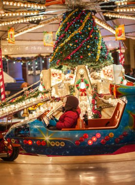 Atlıkarıncada sihirli fütüristik araba kullanan bir çocuk.