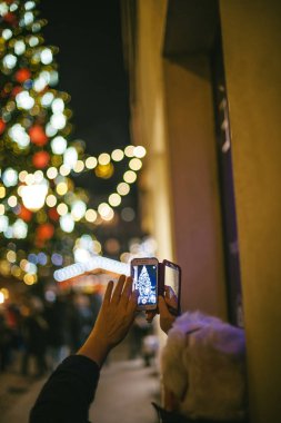 Beyaz saçlı son sınıf öğrencisinin Fransa 'da Noel Pazarı' nda fotoğraf çekerken görüntüsü.