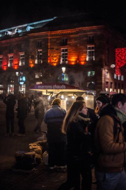 Kestane şarabı satan bir adamın gece görüntüsü kavrulmuş kestaneler ve yayalar