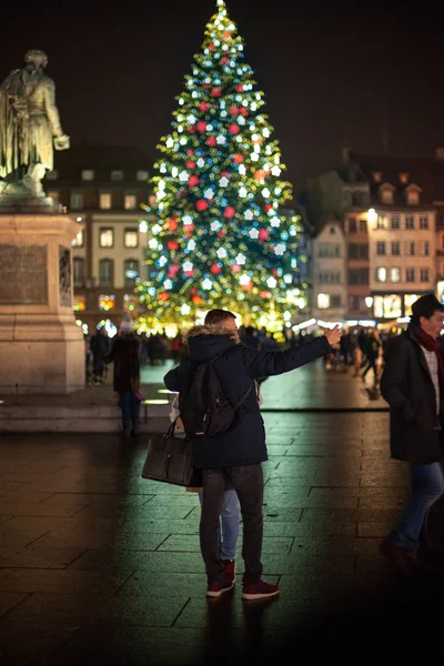 Couple taking photo on the smartphone with tall fir tree Strasbourg Alsace — Stock Photo, Image