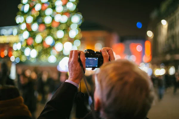 Yaşlı bir adamın aynasız fotoğraf makinesiyle fotoğraf çekerken arka görüntüsü. — Stok fotoğraf