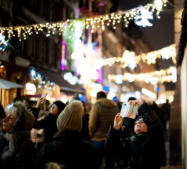 Fransız caddesinde bir grup insan Noel Pazarı 'nın fotoğrafını çekiyor. — Stok fotoğraf