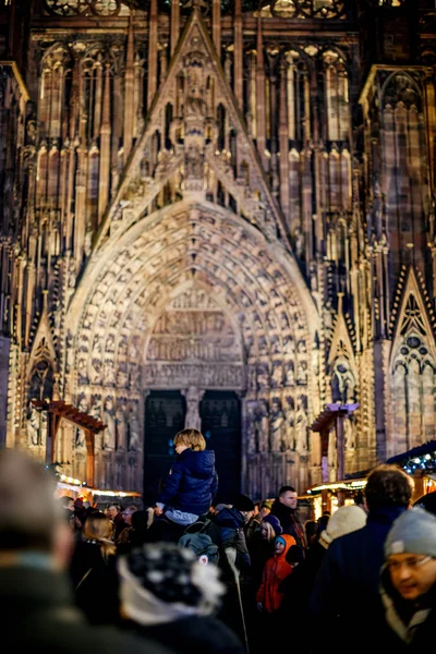 Achteraanzicht van de jongeman op de schouders van vader met de Notre-Dame de Strasbourg — Stockfoto