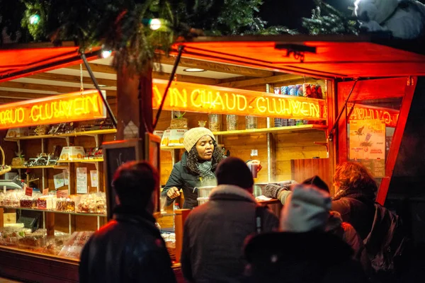 Schwarze Frau verkauft Glühwein an Besucher und Einheimische des jährlichen Weihnachtsmarktes Marche de noel im Zentrum von Straßburg — Stockfoto