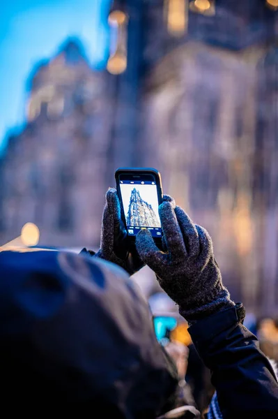 Zadní pohled na turisty objevující vánoční trh ve střední Štrasburku žena fotí smartphone Notre-Dame de Strasbourg — Stock fotografie