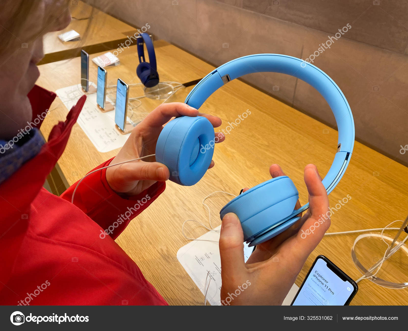 Customer in red coat inside Apple Computers Store testing the new