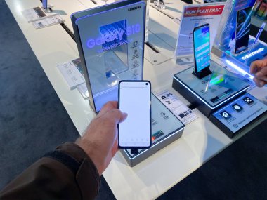 Kırmızı ceketli kadın, Kara Cuma 'dan önce Fnac Fransız elektronik mağazasındaki jet yazıcılar için Epson Ink' in arkasına saklanıyor.