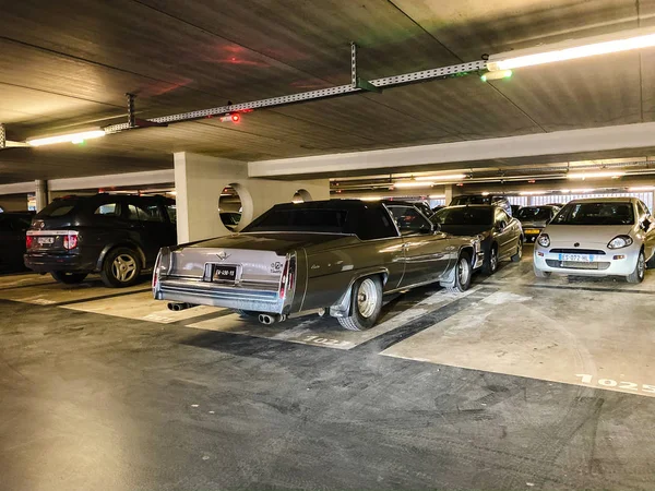 Большой коричневый Cadillac роскошный винтажный двухдверный седан припаркован на современной подземной парковке — стоковое фото
