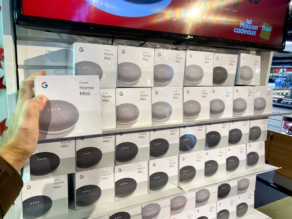 Man χέρι Pov κοιτάζοντας το Google Home Mini smart speaker στο εσωτερικό Fnac γαλλικό ηλεκτρονικό κατάστημα εμπορικό κέντρο πριν από Black Friday ασχολείται — Φωτογραφία Αρχείου