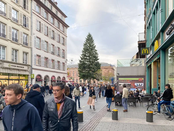 Miejscowi i turyści spacerujący główną ulicą w Strasburgu z wysoką jodłą w tle podczas corocznego jarmarku bożonarodzeniowego — Zdjęcie stockowe