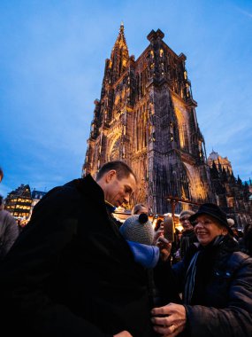 Büyükanne Notre-Dame de Strasbourg katedrali ile gülümsüyor.