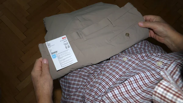 Uomo anziano unboxing disimballaggio pacchetto di plastica negozi Uniqlo — Foto Stock