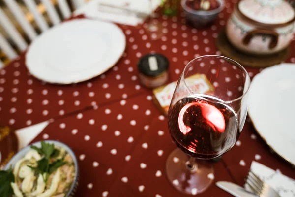 Copa con vino tinto en mantel festivo listo para Navidad — Foto de Stock