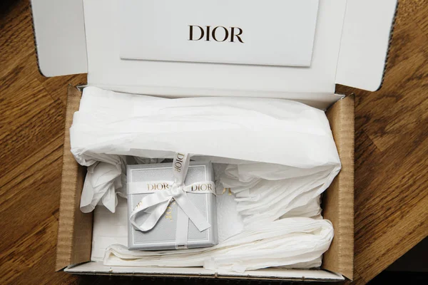 Вид сверху на пакет Dior с подарком внутри - коробка подарка на праздник с логотипом шелка между тонкой белой бумагой — стоковое фото