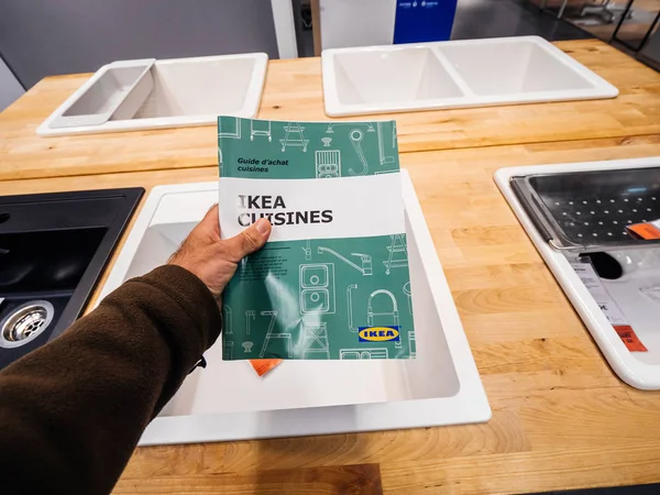 Мужчина держит в руках новейший катафалк с Ikea Cuisines Kitchen в специально отведенной зоне мебельного магазина — стоковое фото