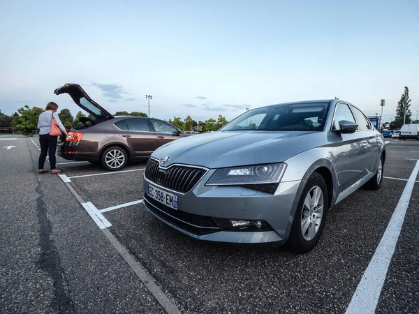 Large IKEA furniture parking with two Skoda cars Octavia and Superb parked in the evening woman loading goods in trunk — ストック写真