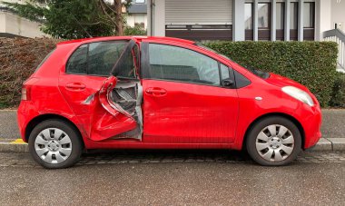 Yeni lüks kırmızı küçük Toyota arabanın yan görüntüsü kazara arka kapı parçalandı - yağmurlu bir gün