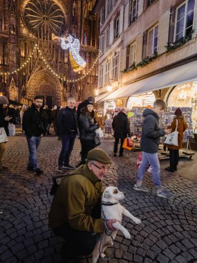 Notre Dame 'ın önünde poz veren sevimli köpekli yetişkin bir adam.