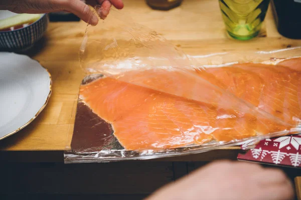 Woman hand open fresh packaging of salmon red bio organic filet meat — Stock Photo, Image