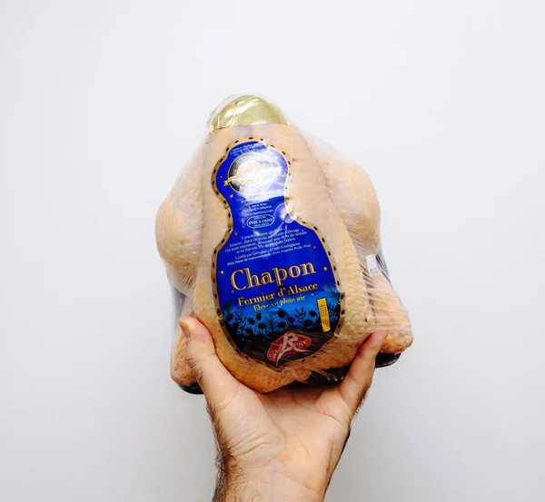 Man hand holding against white background fresh Capon Chapon cockerel meat — 스톡 사진