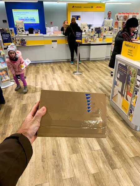 Man tangan memegang amplop pos dalam memasuki kantor pos Postbank dalam perspektif pribadi POV kota Jerman — Stok Foto