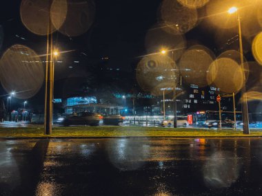 Yağmurlu havalarda camında sinematik bir çukur ve arka planda Avrupa İnsan Hakları Mahkemesi binasının arka planında, Strasbourg 'da yağmurlu bir günde arka planda sürüş yapan araba siluetleri vardı.