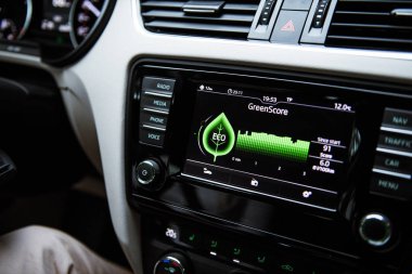 Modern Skoda Octavia yeşil kirlilikten arınmış, yeni hibrit arabanın üzerinde birden fazla düğmesi olan gösterge panelindeki yeşil çizginin ayrıntıları